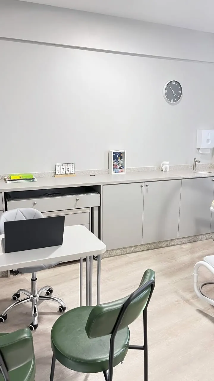 Consultório odontológico com cadeira verde e ambiente claro